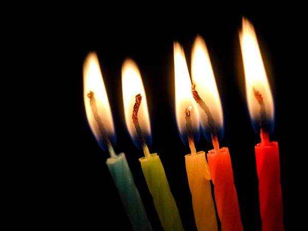5 gekleurde, brandende kaarsjes in het donker