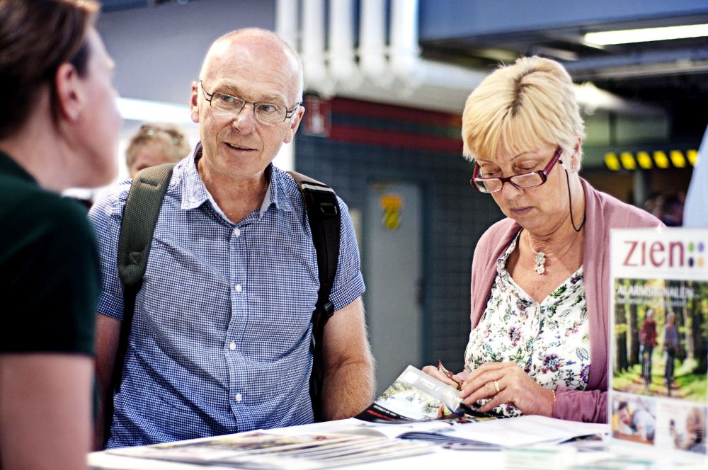 Bezoekers van de Oogstraat op de 50PlusBeurs in gesprek
