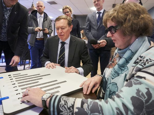 Minister Bruins en Marianne Huijben bekijken samen de stemmal voor de verkiezingen
