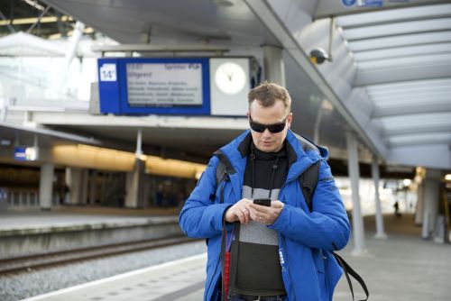 Peter Waalboer met smartphone op het station
