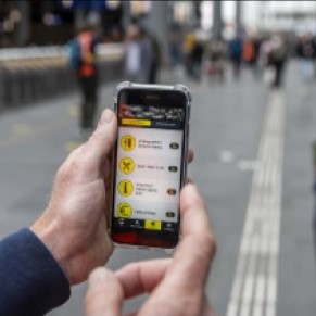 Smartphone met route op scherm en geleidelijn op de achtergrond van de foto.