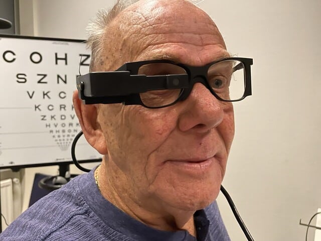 Man met speciale bril staat voor letterbord
