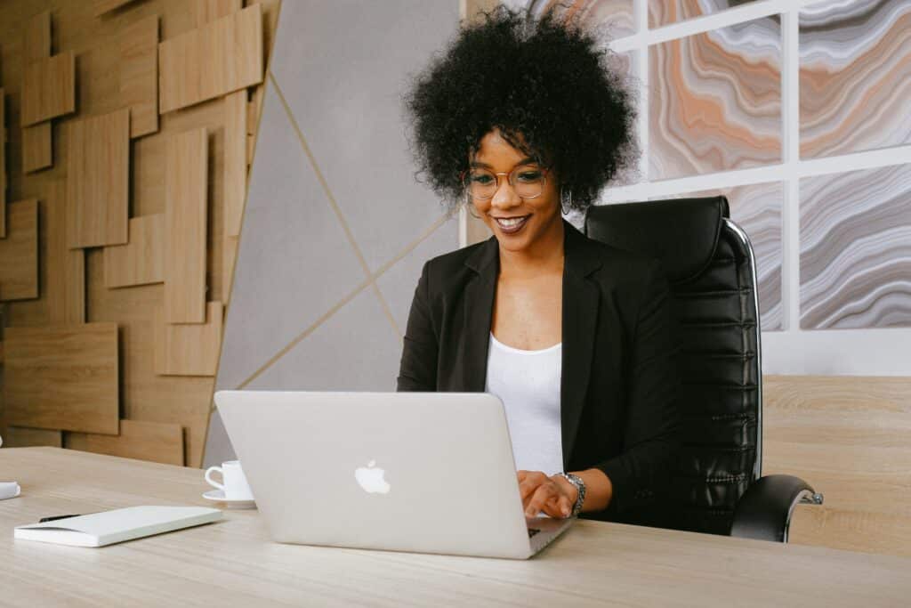 Vrouw met lachend gezicht achter laptop