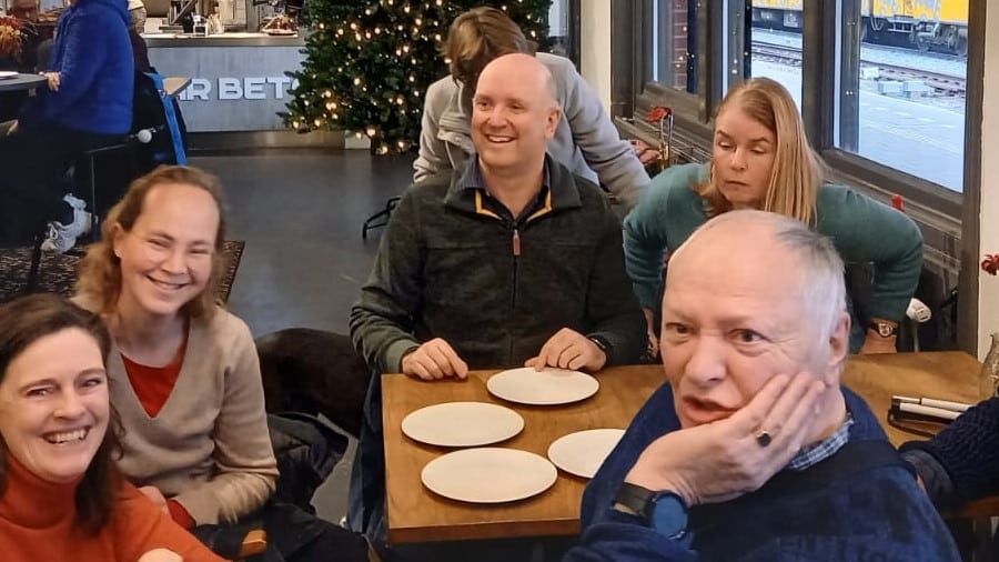 Vrijwilligers en medewerkers van de Oogvereniging met elkaar aan tafel in een café op de Oogcafédag 2022