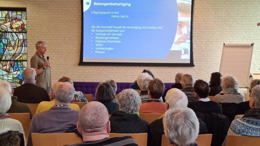 mensen zitten in een collegezaal en kijken naar een presentatie