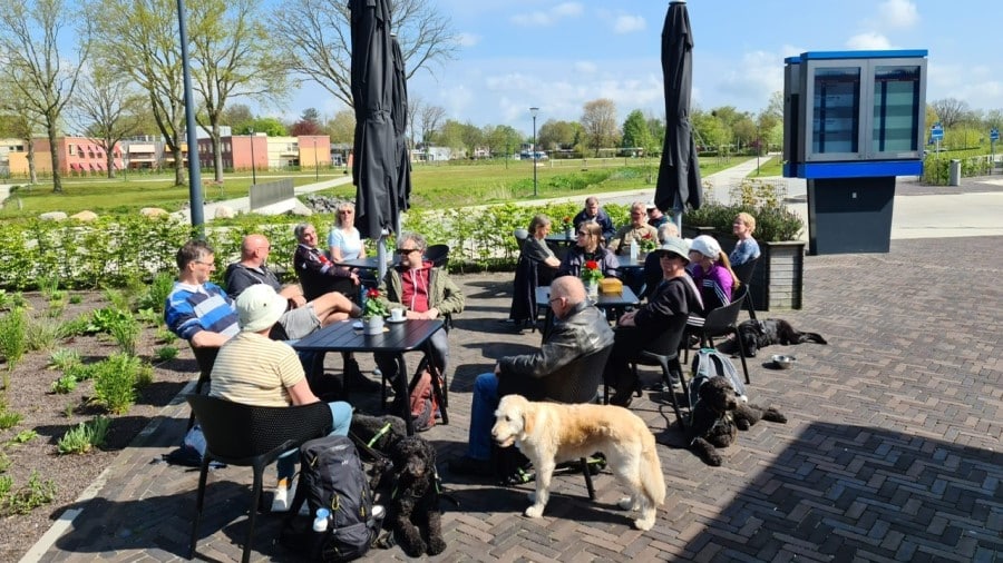 Mensen zitten buiten aan tafels te lunchen in het zonnetje