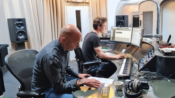 twee mannen zittend achter mengpaneel in studio