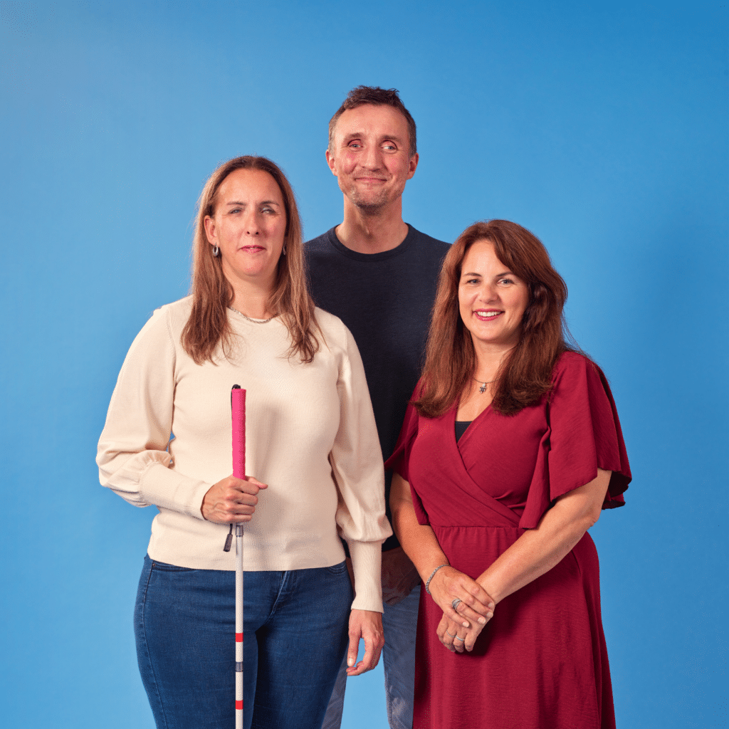 twee dames en een man lachend voor een blauwe achtergrond