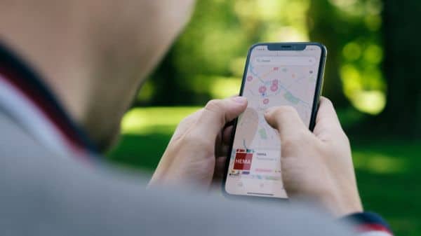 man houdt mobiele telefoon vast met google maps