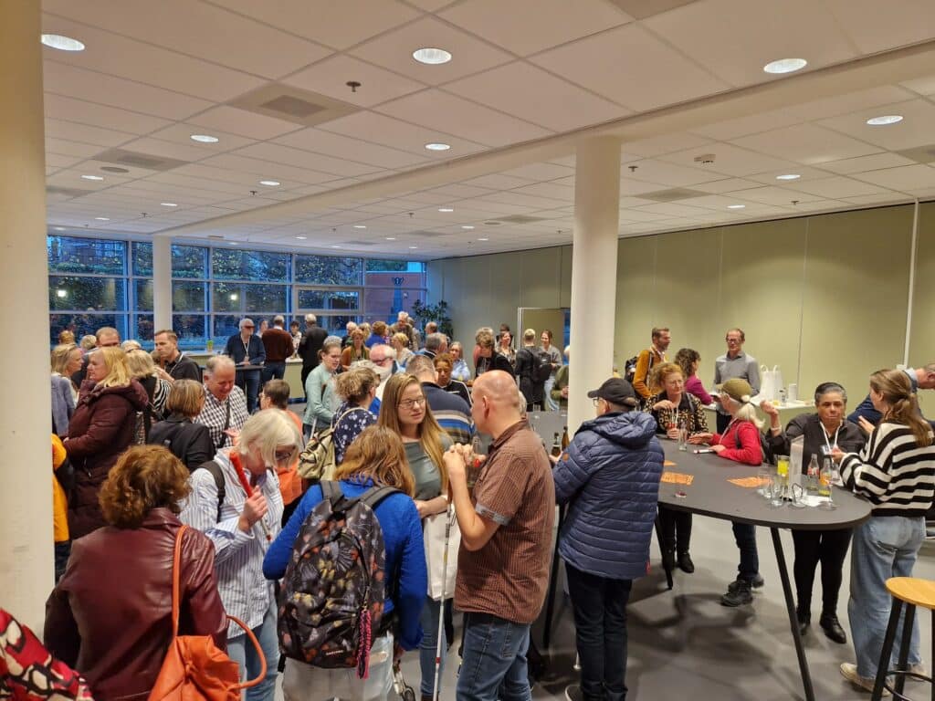 een volle foyer met bezoekers van het oogcongres