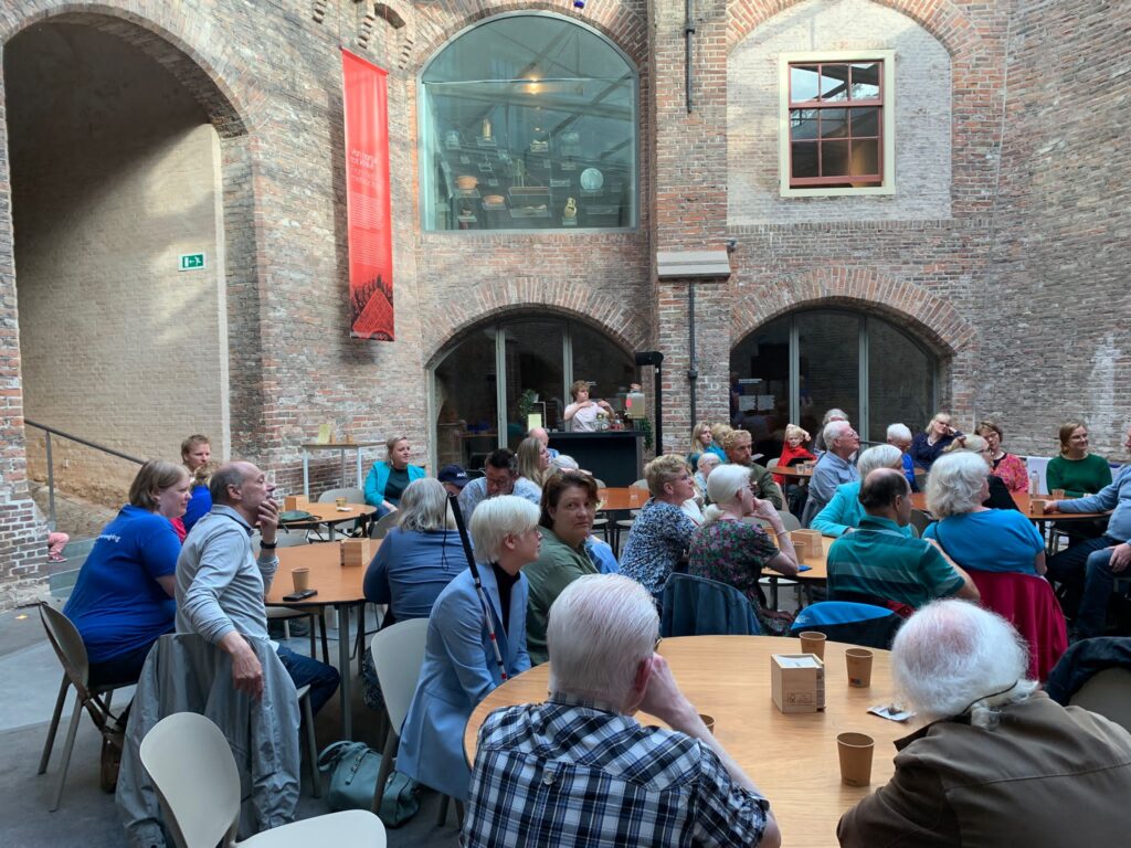 de gasten drinken koffie aan tafels in een ruimte met oude muren uit bakstenen