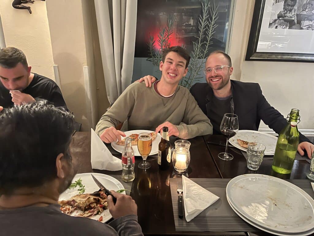 twee bezoekers lachen samen met een biertje voor zich op tafel