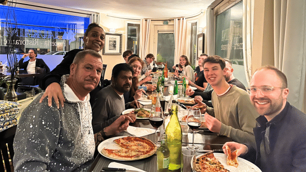 een lange tafel in een pizzeria met jonge leden van de oogvereniging
