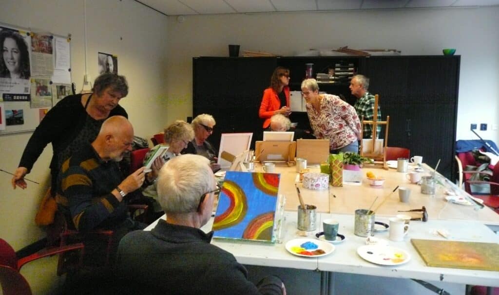 tien enthousiaste schilders zijn bezig met hun eigen schilderij of lopen rond om de andere werken te bekijken