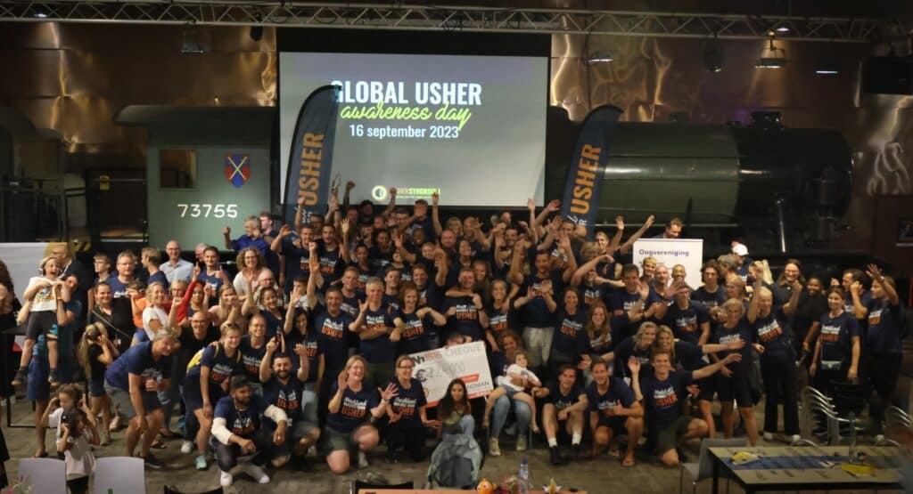 zo'n 50 mensen lachend op de foto op de usher awareness day