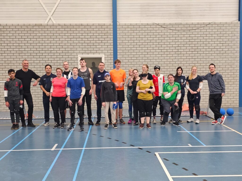 carlo duister met de hele groep goalballers in een sportzaal