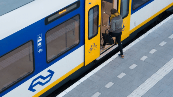 reiziger stapt vanaf het perron in een sprinter trein