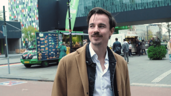 een beeld uit de documentaire: kees staat op een druk plein in utrecht, hij wordt geinterviewd