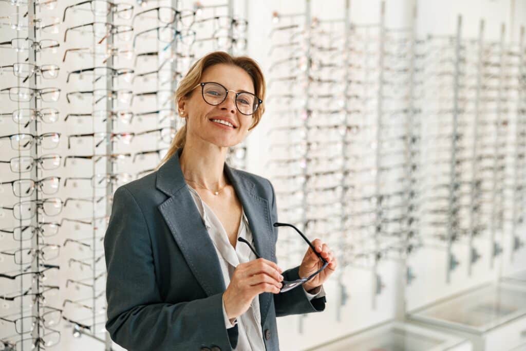 een vrouw zoekt een bril uit bij een optiekzaak