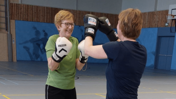 twee vrouwen doen samen een oefening met bokshandschoenen aan