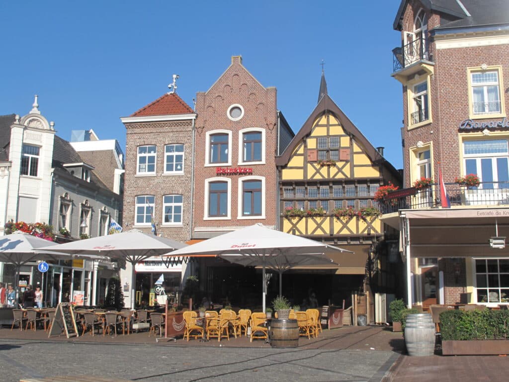 middeleeuwse gebouwen in het centrum van sittard. het is zonnig weer en er zijn terrasjes opgebouwd., waar overigens nog niet niemand lijkt te zitten.