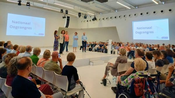 Bezoekers van het Oogcongres luisteren in de zaal naar de sprekers op het podium