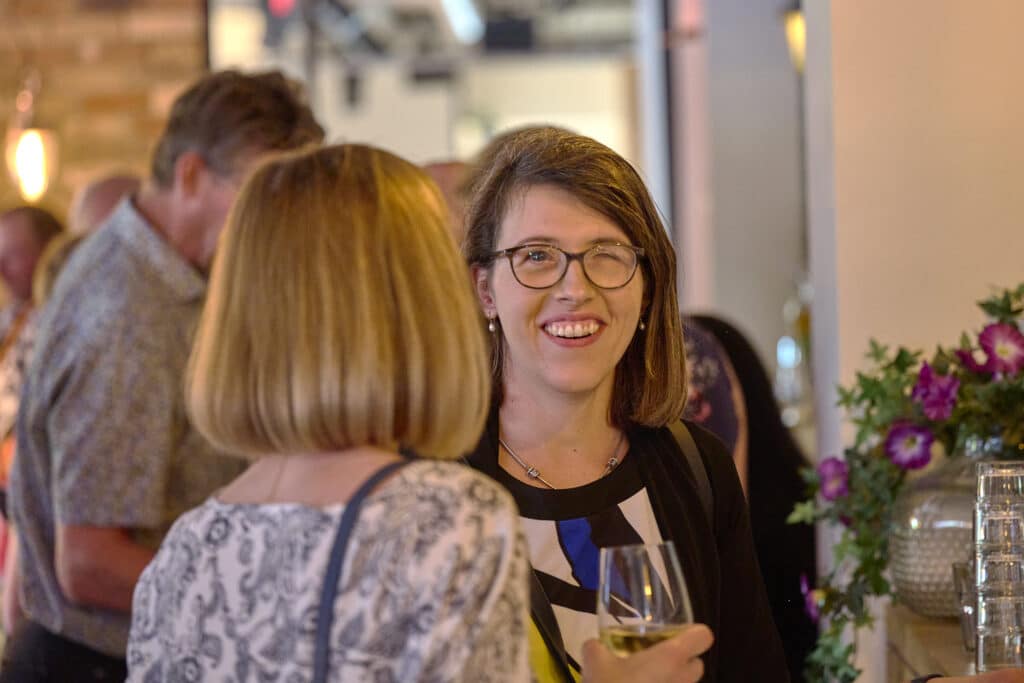 twee dames kletsen na tijdens de borrel met een biertje in de hand