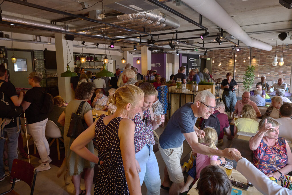 een zaal vol bezoekers tijdens de borrel van de verenigingsdag in 2022
