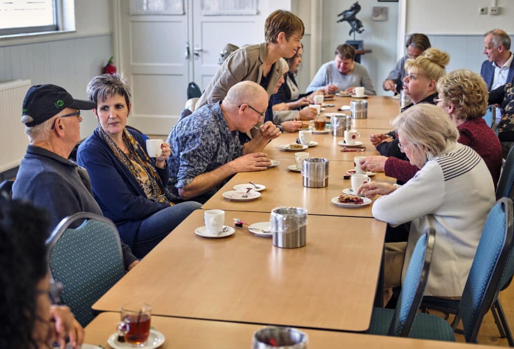 Bezoekers van een oogcafé met elkaar in gesprek