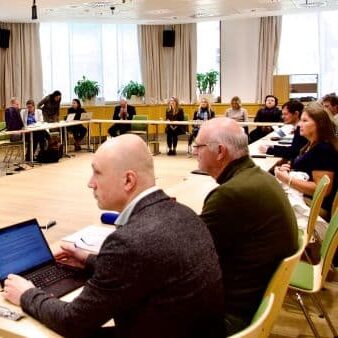 Leden van de European Blind Union zitten bij elkaar in een vergaderzaal