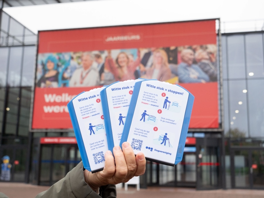Een hand houdt drie parkeerschijven omhoog bij de ingang van de Jaarbeurs Utrecht