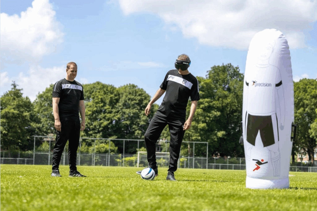 Twee deelnemers aan blindenvoetbal staan op het veld
