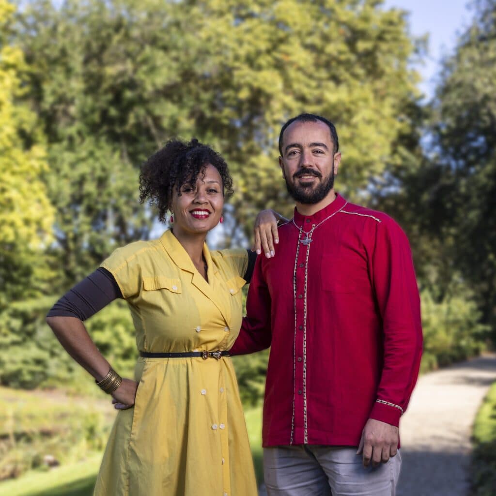 Een vrouw en man staan op een zonnige dag in een park en lachen naar de camera