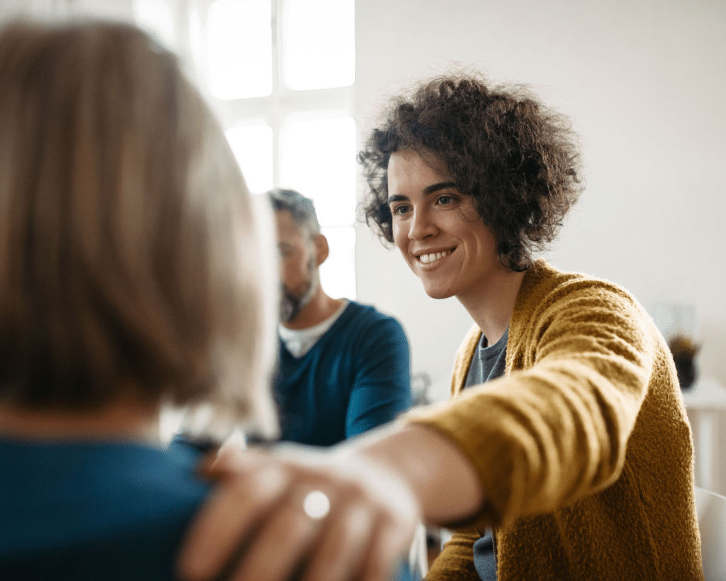 Een vrouw legt haar hand op iemands schouder