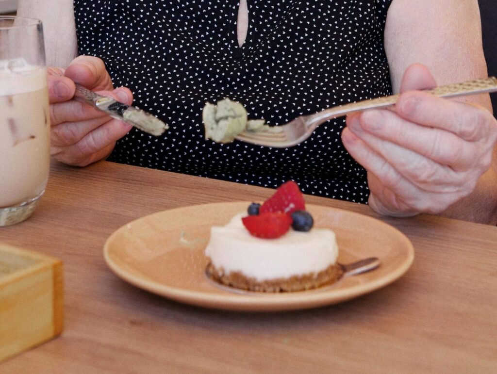 Iemand eet met mes en vork een gebakje