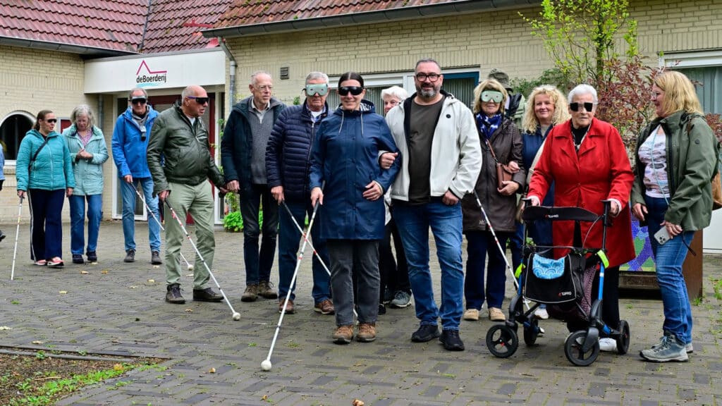 een grote groep mensen start een wandeling met de witte stok
